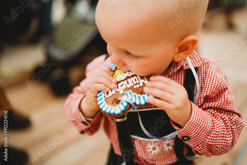 Young boy in lederhosen eating cookie heart Oktoberfest Munich