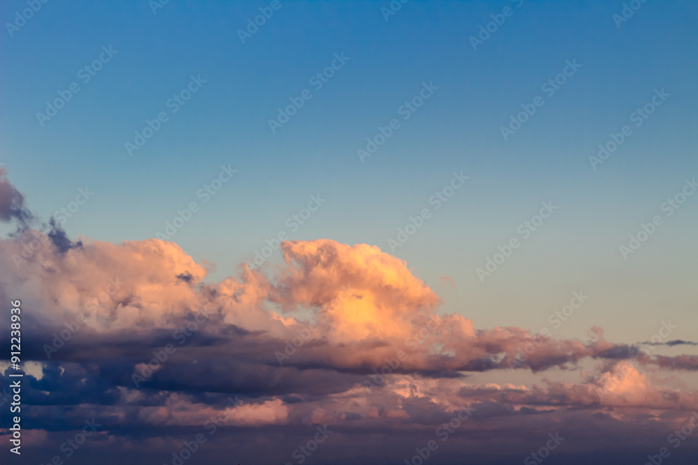 Fototapeta premium Dramatic clouds in the blue sky in the morning, the rising sun rays hitting the clouds