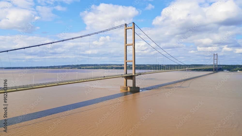 Aerial drone view of Humber Bridge, 12th largest suspension span, gracefully crossing River Humber, connecting Lincolnshire to Humberside with traffic. Aerial drone view of Humber Bridge, 12th largest suspension span, gracefully crossing River Humber, connecting Lincolnshire to Humberside with traffic.