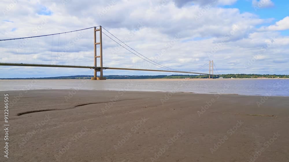 Aerial drone view of Humber Bridge, 12th largest suspension span, gracefully crossing River Humber, connecting Lincolnshire to Humberside with traffic. Aerial drone view of Humber Bridge, 12th largest suspension span, gracefully crossing River Humber, connecting Lincolnshire to Humberside with traffic.