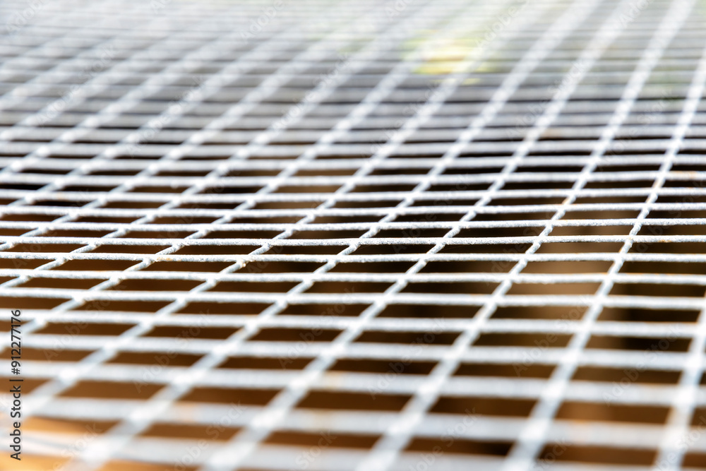 Close-up shot of a metal mesh with a slightly blurred background. Abstract geometric backgrounds Close-up shot of a metal mesh with a slightly blurred background. Abstract geometric backgrounds