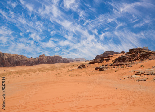 Wadi Rum Desert also known as The Valley of the Moon (against the sky with clouds)-- is a valley cut into the sandstone and granite rock in southern Jordan 60 km to the east of Aqaba