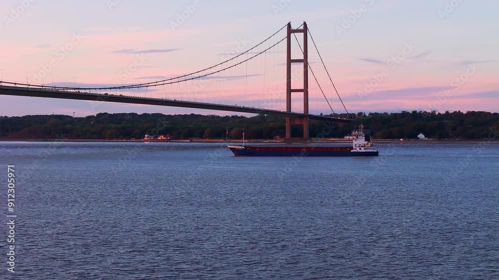 Sunset silhouette: Humber Bridge and the graceful flow of cars. Sunset silhouette: Humber Bridge and the graceful flow of cars.