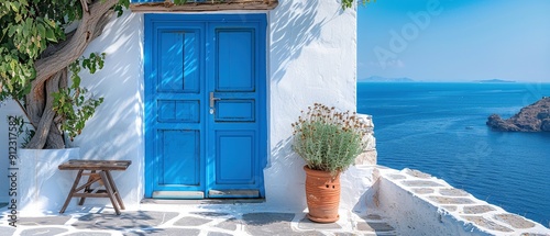 Fototapeta Naklejka Na Ścianę i Meble -  A blue door with a white trim sits in front of a house with a view of the ocean