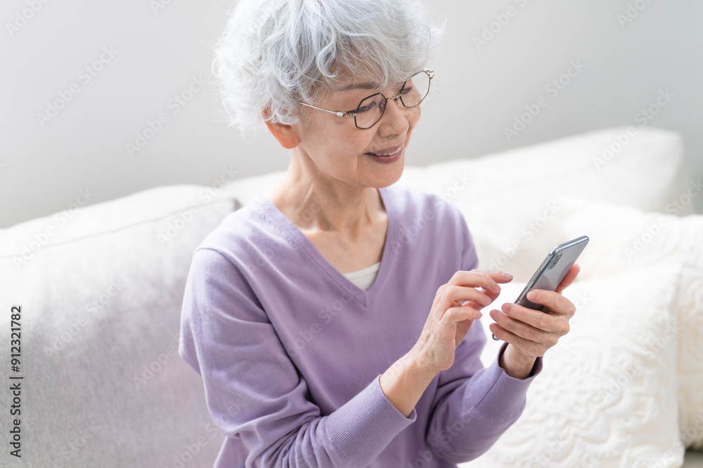 スマートフォンを操作しているシニア女性 スマートフォンを操作しているシニア女性