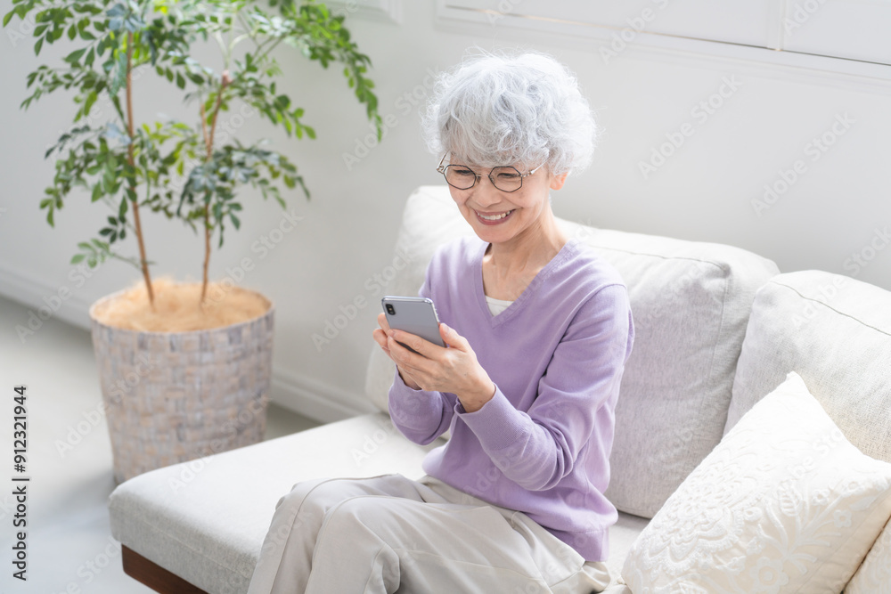 スマートフォンを操作しているシニア女性 スマートフォンを操作しているシニア女性