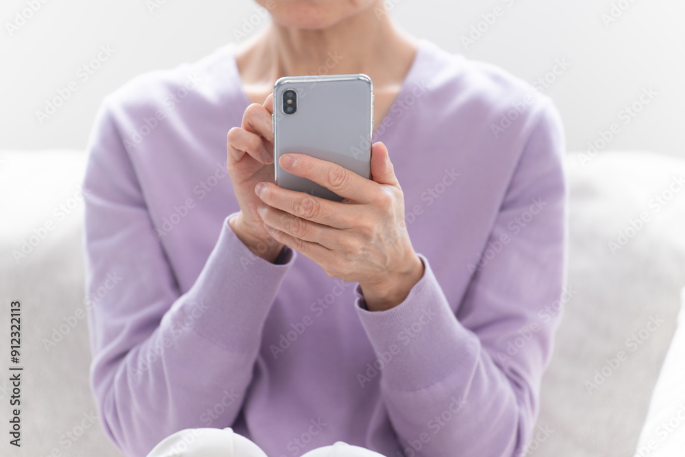 スマートフォンを操作しているシニア女性 スマートフォンを操作しているシニア女性
