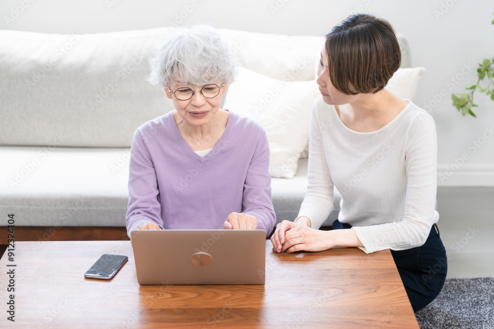 若い女性にパソコン操作を習うシニア女性