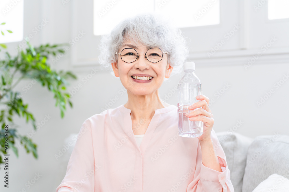 ペットボトルの水を飲むシニア女性 ペットボトルの水を飲むシニア女性