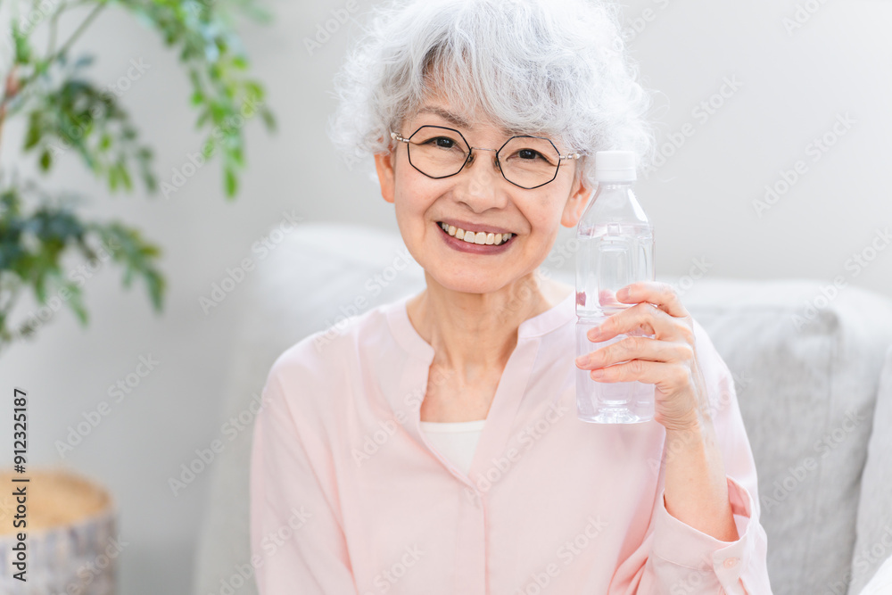 ペットボトルの水を飲むシニア女性 ペットボトルの水を飲むシニア女性