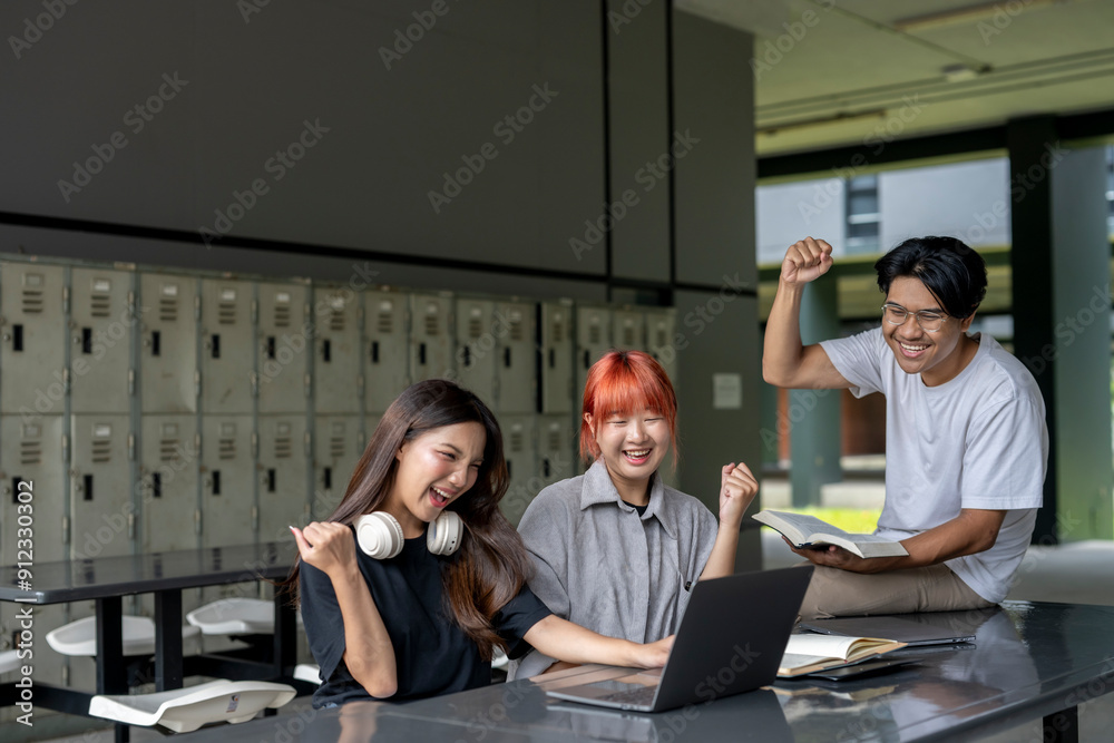 Three people are sitting at a table with a laptop open Three people are sitting at a table with a laptop open