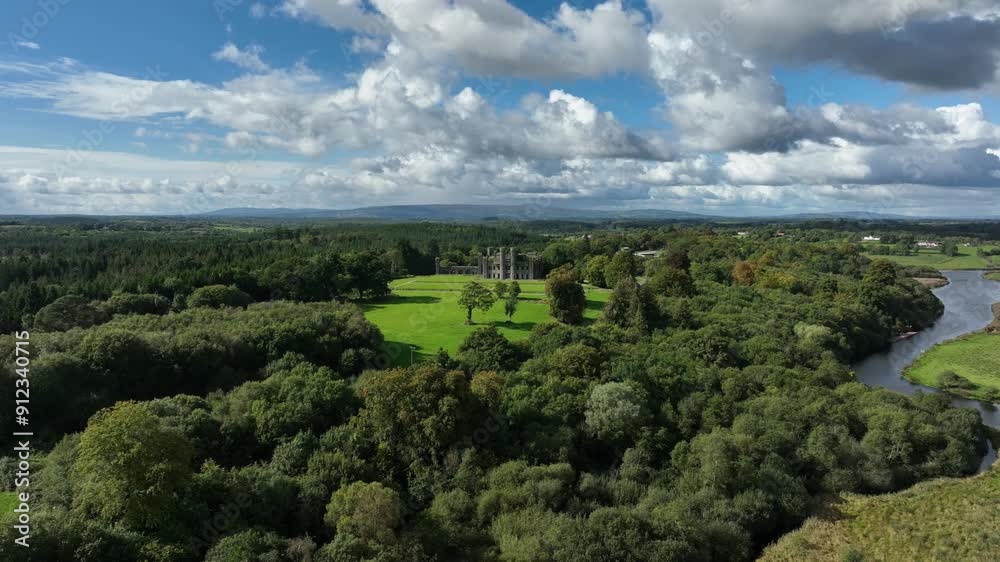 Castle Saunderson, County Cavan, Ireland, September 2022. Drone orbits clockwise around the old Gothic Revival Castle ruins with lawns surrounded by trees with the Finn River in the background. Castle Saunderson, County Cavan, Ireland, September 2022. Drone orbits clockwise around the old Gothic Revival Castle ruins with lawns surrounded by trees with the Finn River in the background.