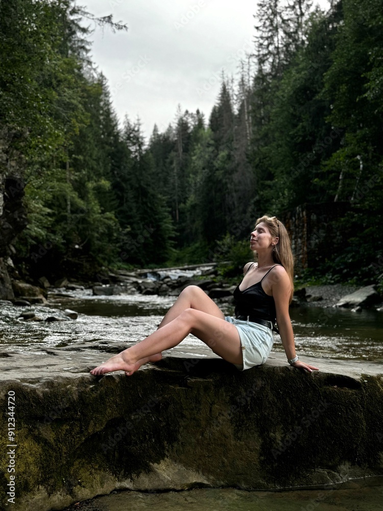 Fototapeta premium person sitting on the rocks