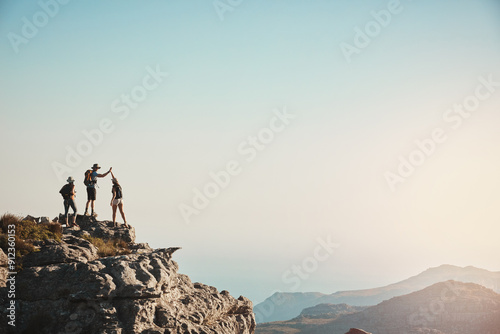 Friends, hiking and high five on mountain for fitness success, adventure view and backpack journey in summer. People, achievement and trekking together for cardio exercise, rock climbing and health