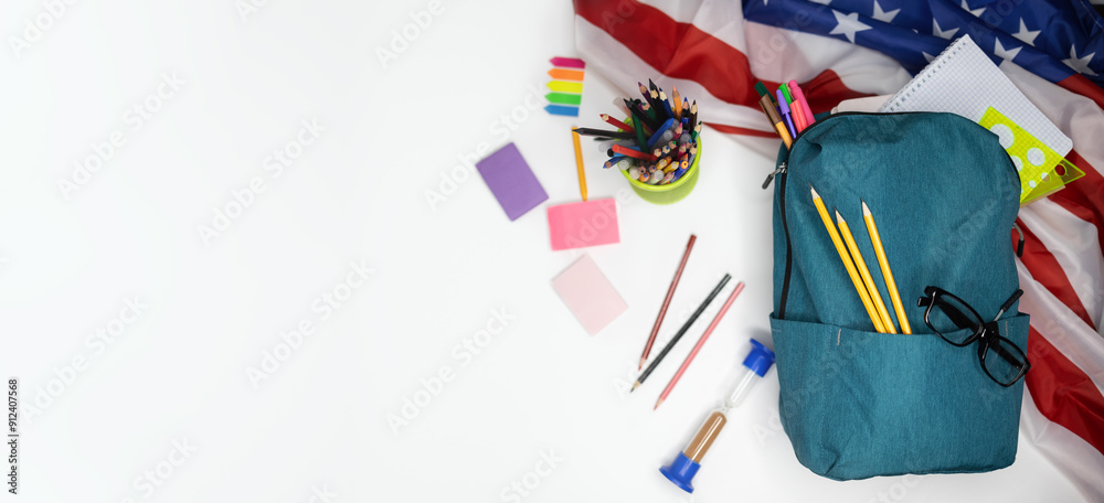 Obraz premium Top view flat lay banner backpack arranged on isolated white background blank circle for text or advertisement American flag. Concept: beginning of the school year back to school. Education in America