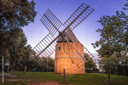 Scenic view of Les Moulins de Paillas windmill near Ramatuelle in Saint Tropez bay in south of France against summer sunset sky
 photo