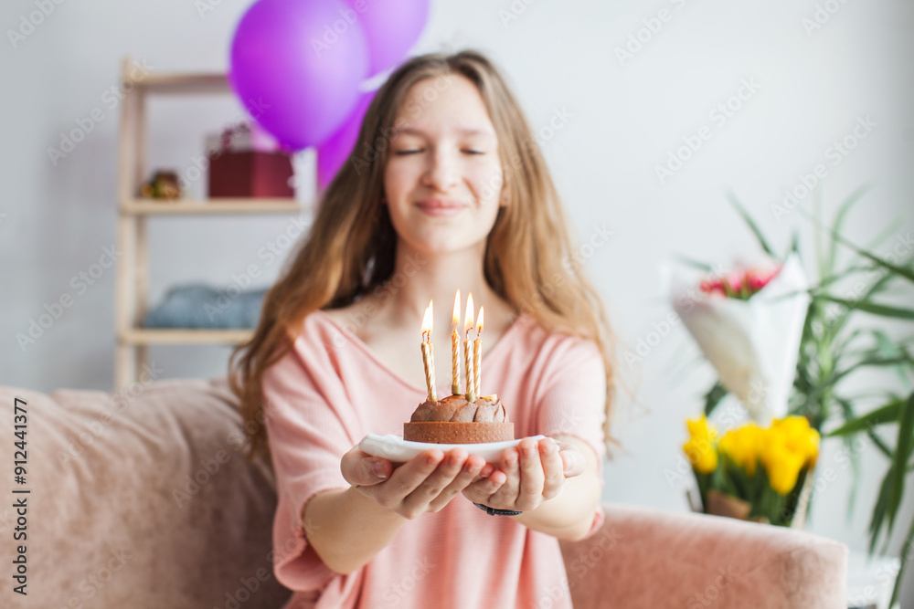 young woman looking at birthday cake with candle young woman looking at birthday cake with candle