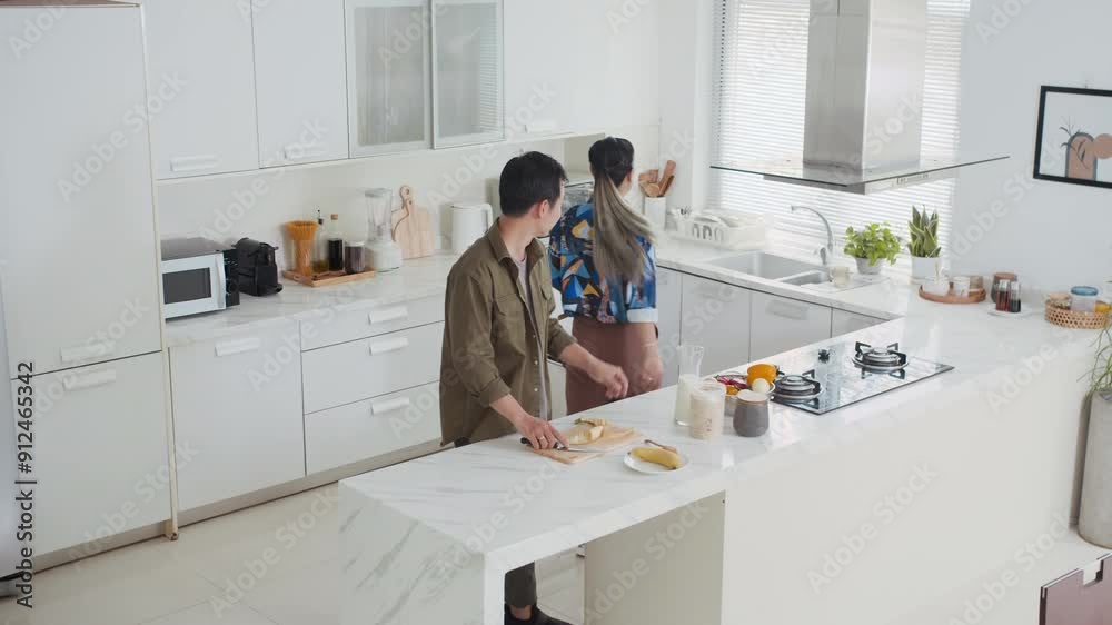 View from above of young Asian spouses preparing breakfast at home kitchen at weekend View from above of young Asian spouses preparing breakfast at home kitchen at weekend
