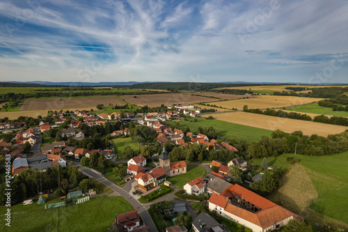 Obraz na płótnie Aer ial view of a German village surrounded by meadows, farmland and forest. Thuringia, Germany. w salonie