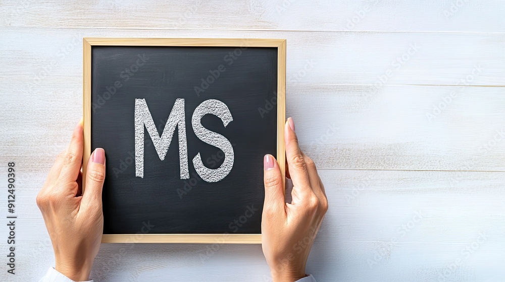Hands Holding a Black Chalkboard With the Letters MS in a Bright Room Hands Holding a Black Chalkboard With the Letters MS in a Bright Room