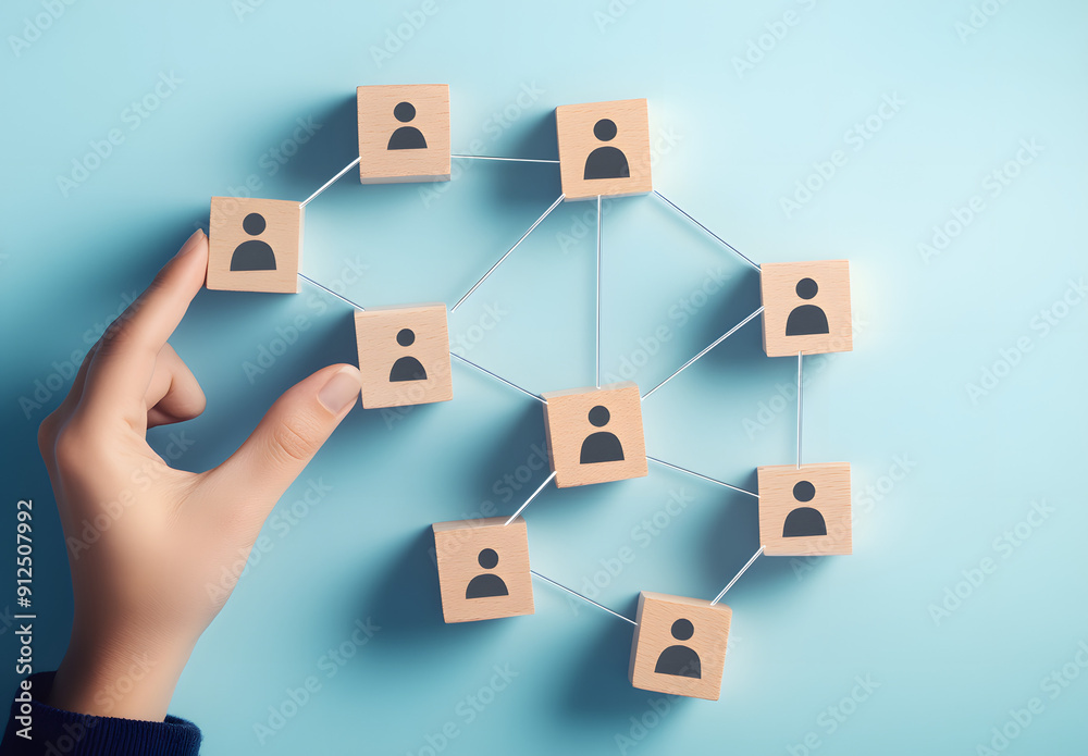 A Hand Connecting Wooden Blocks with Human Icon Figures Symbolizing Team Building and Collaboration A Hand Connecting Wooden Blocks with Human Icon Figures Symbolizing Team Building and Collaboration