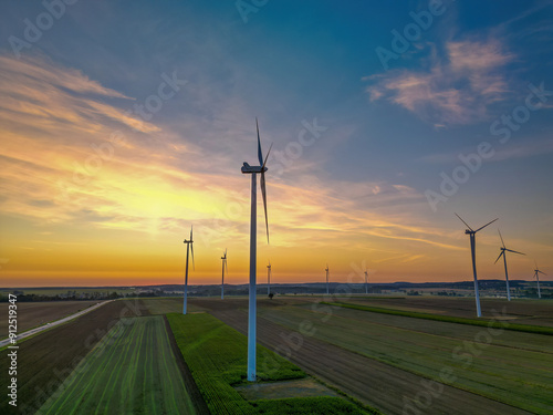 Wind turbines in the field during sunrise, representing renewable energy and sustainability.