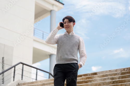 Confident Young Businessman Talking on Smartphone Outdoors Near Modern Office Building