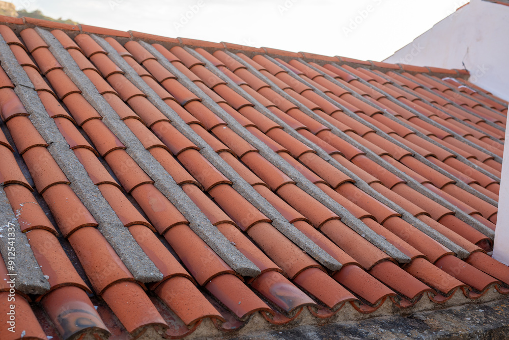 A close up of a tiled roof with rows of terracotta tiles A close up of a tiled roof with rows of terracotta tiles