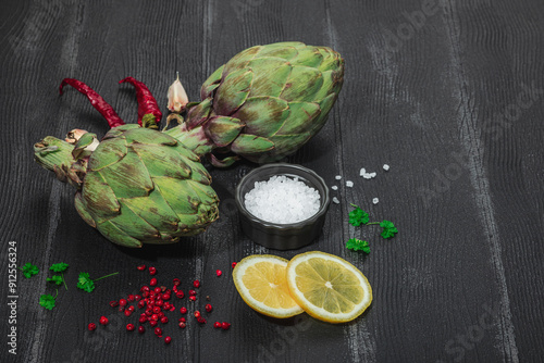 Fresh green artichokes cooking on wooden background. Traditional seasonal ingredients photo