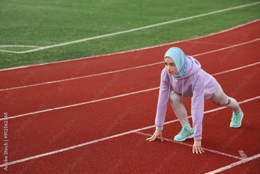 Fototapeta premium Sporty Muslim woman getting ready to run at stadium