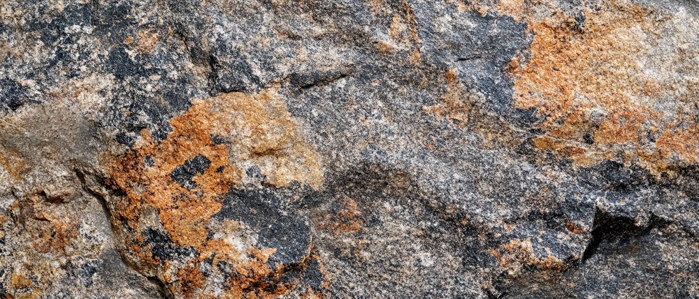 Obraz premium Close-up of rough granite rock surface displaying natural color variations and crystalline structures