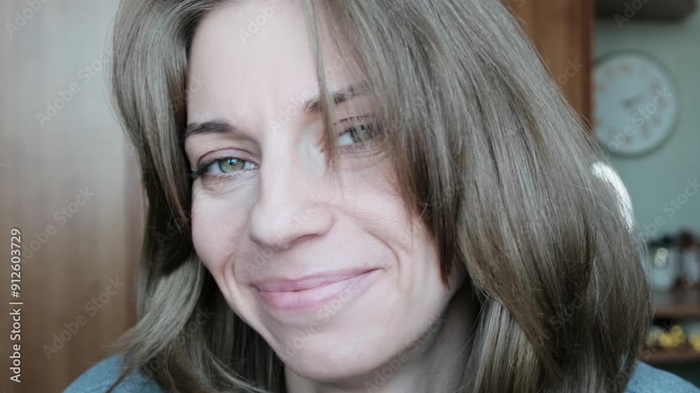 Portrait of a beautiful woman with green eyes smiling sweetly at the camera.