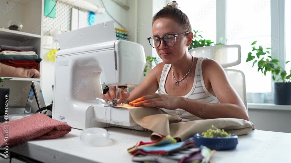 A Creative Woman Engaged in Sewing with a Variety of Colorful Fabrics in a Modern Workspace A Creative Woman Engaged in Sewing with a Variety of Colorful Fabrics in a Modern Workspace