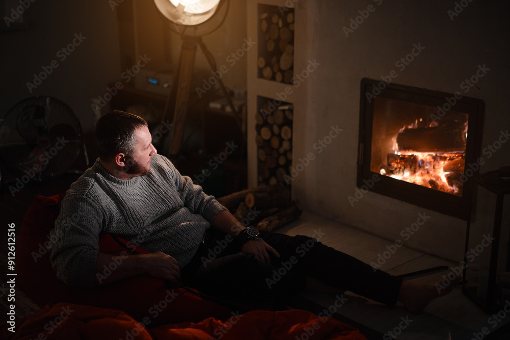 Man sitting at home by the fireplace Man sitting at home by the fireplace