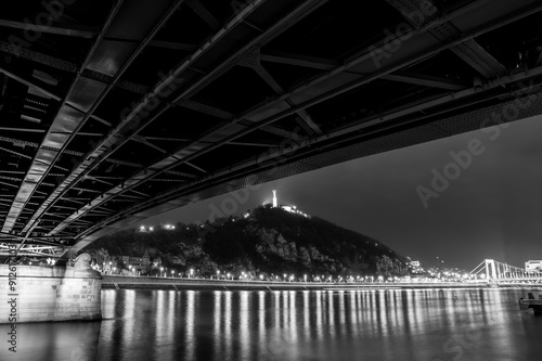 A stunning night view of Budapest featuring the illuminated Chain Bridge and Gellért Hill, with the Danube River reflecting the city’s lights.