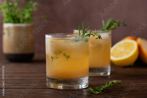 Pear lemonade with lemon, rosemary, thyme and ice on a wooden table. Healthy drink, sugar and alcohol free.