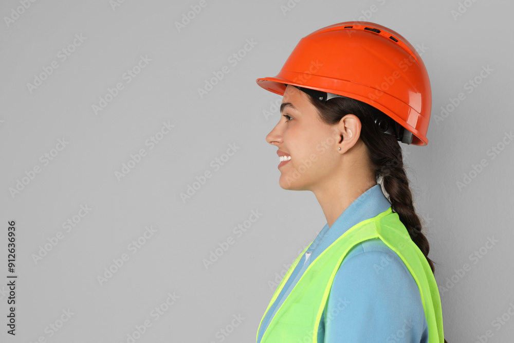 Engineer in hard hat on grey background, space for text Engineer in hard hat on grey background, space for text
