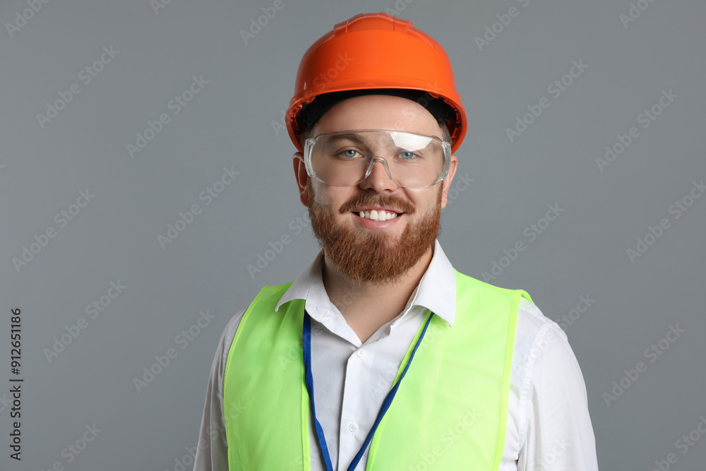 Engineer in hard hat and goggles on grey background Engineer in hard hat and goggles on grey background