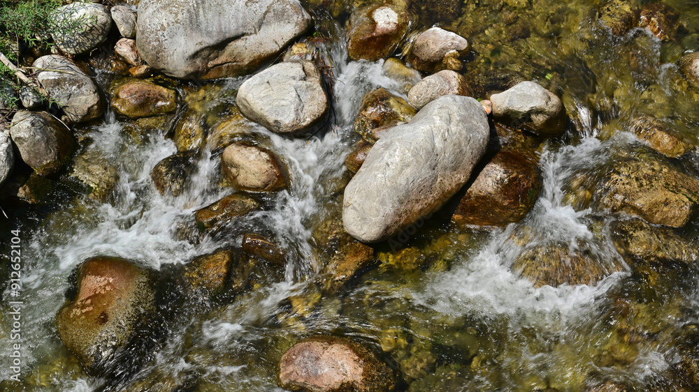 Stream with bubbling sparkling water and stones in the mountain river Stream with bubbling sparkling water and stones in the mountain river