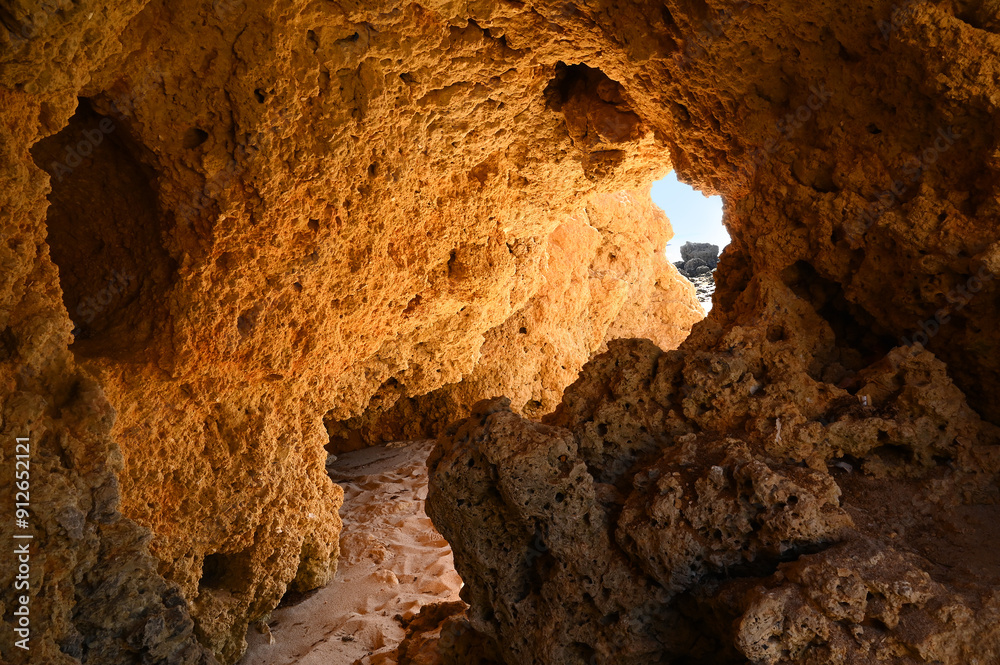 Fototapeta premium Beautiful red rocks cave with atlantic sea and beach in the Algarve on vacation in Portugal, Europe.