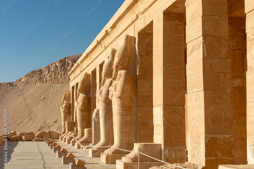Fototapeta premium The columns of the temple of Hatshepsut in Luxor are adorned with statues of the pharaoh. This architectural masterpiece is a testament to the rich history and artistic achievements of ancient Egypt.