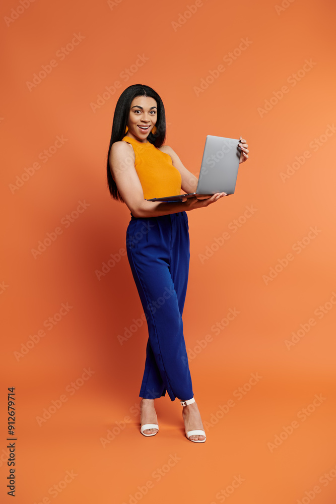 A stylish woman presents her laptop with a vibrant smile.
