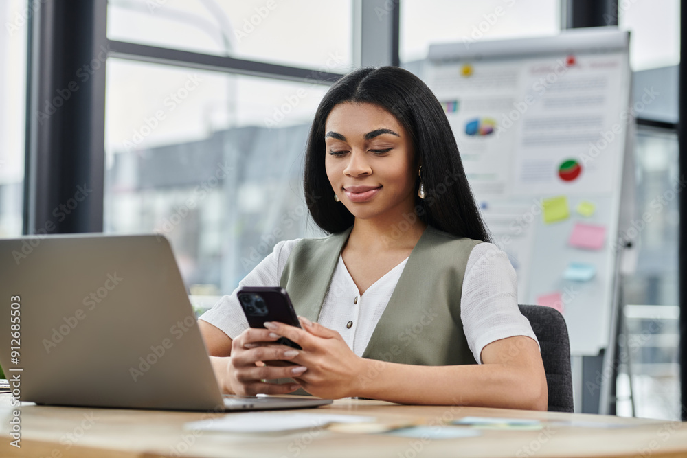 A confident woman enjoys a conversation on her smartphone while working. A confident woman enjoys a conversation on her smartphone while working.
