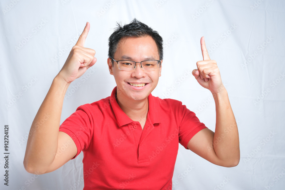 Smiling happy Young Asian man pointing both hands up on white background. studio shot Smiling happy Young Asian man pointing both hands up on white background. studio shot