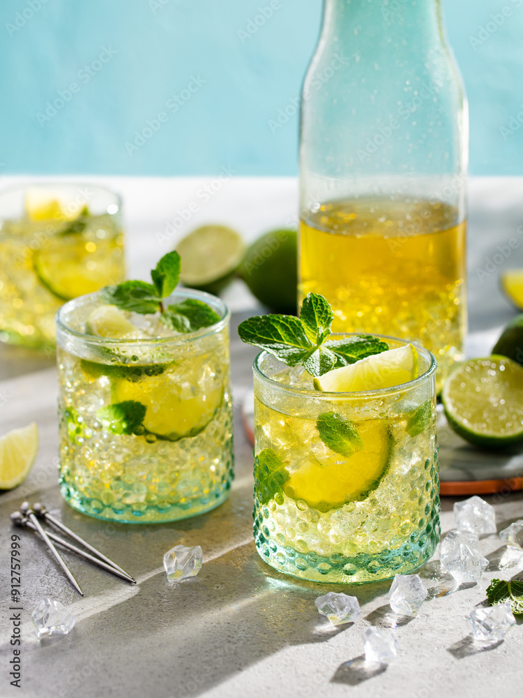 Fototapeta premium Lemonade with lemon and mint. Cocktail, ice tea in glasses and jug. Grey background.