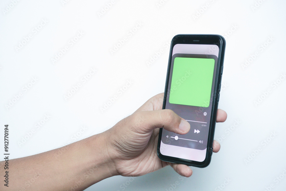 Hand holding a smart phone which displays a media player app Hand holding a smart phone which displays a media player app