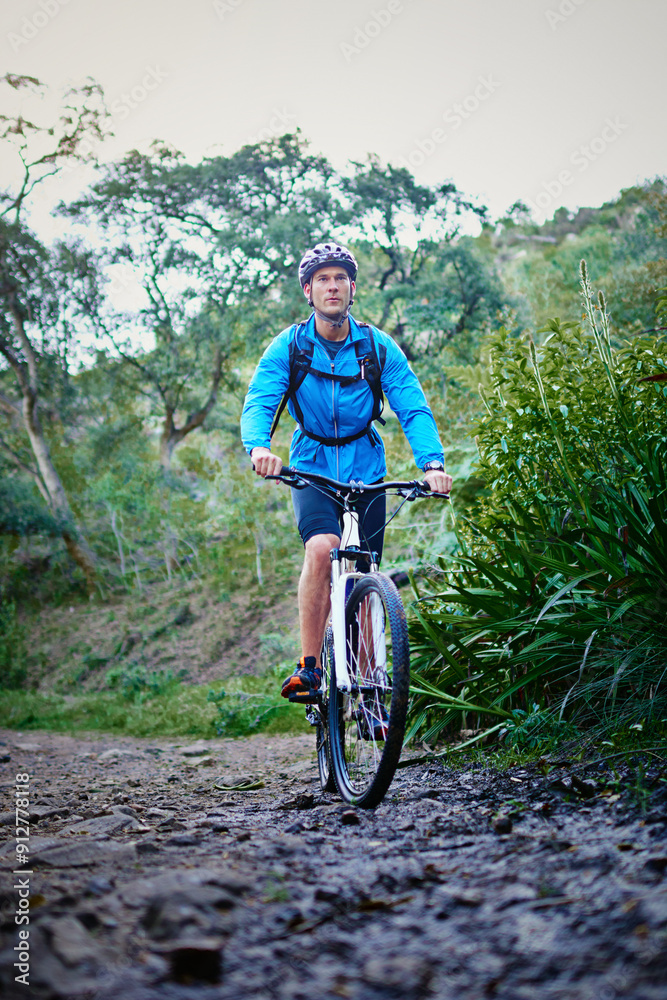Naklejka premium Man, exercise and mountain bike on off road with helmet, plants and challenge for fitness, adventure and health. Athlete, journey and cycling outdoor in nature for workout, sports and training