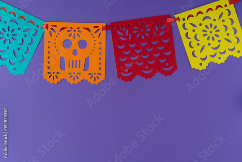 Garland with Mexican decoration, papel picado on purple background.