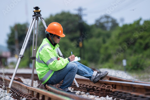 Surveyor builder site engineer with theodolite total station at Railway site outdoors during surveying work