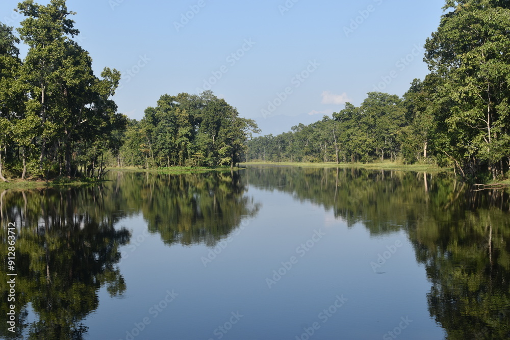 A perfect lake reflection in the jungle and rainforest around Chitwan, Nepal A perfect lake reflection in the jungle and rainforest around Chitwan, Nepal